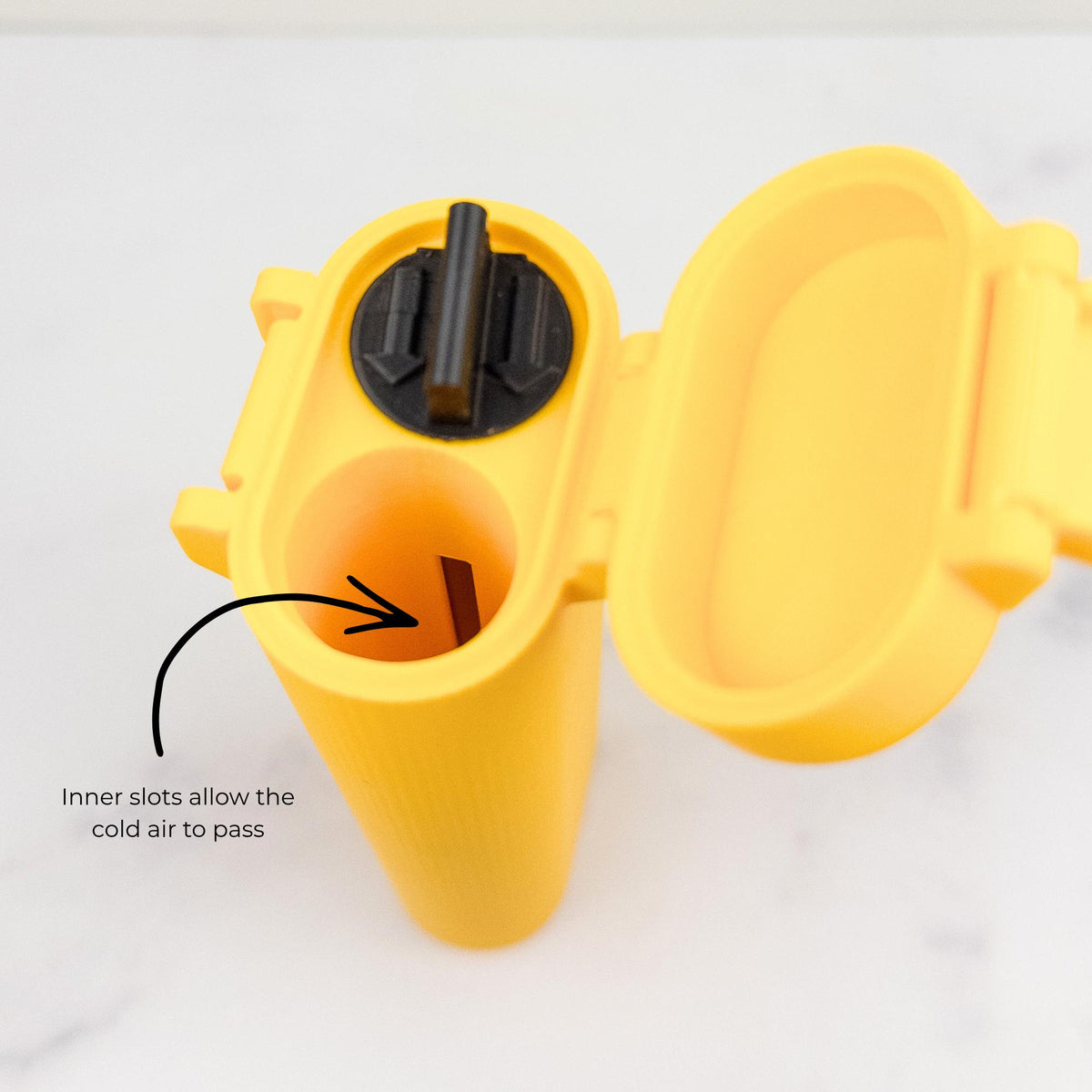 a yellow container with a black lid, and there is a black arrow pointing to the inner slots, indicating that the cold air can pass through.