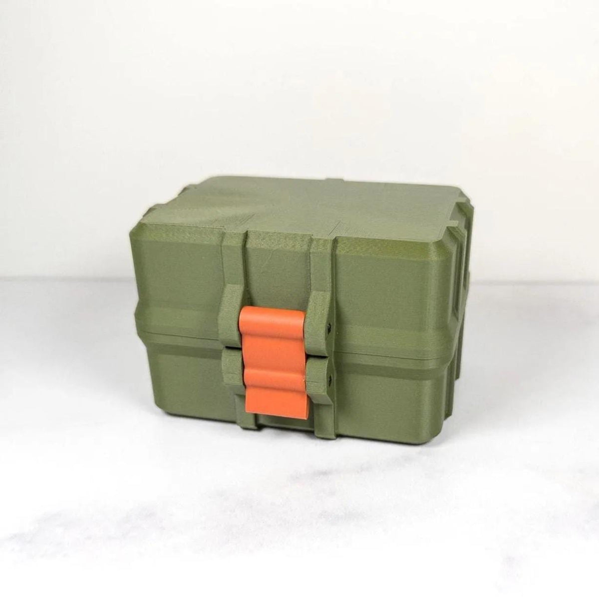 A green and orange plastic toolbox with a red handle, sitting on a white surface.