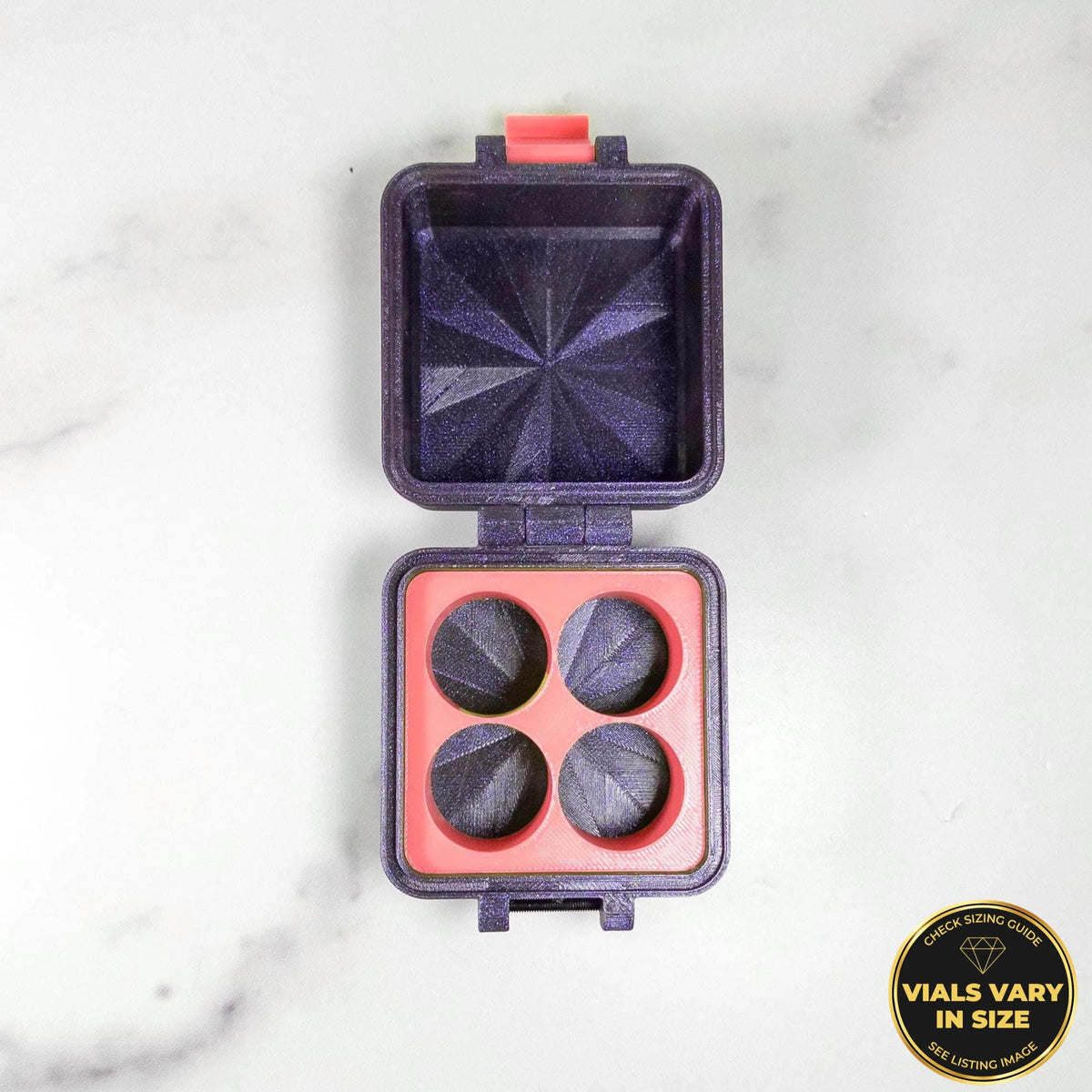 a purple and red makeup container with four compartments, placed on a white marble surface.