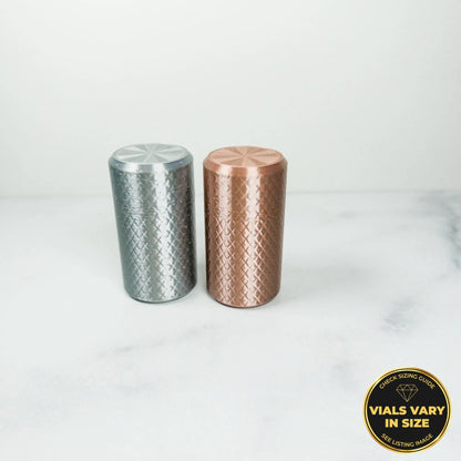 Two cylindrical objects, one silver and one copper, are placed on a white marble surface.