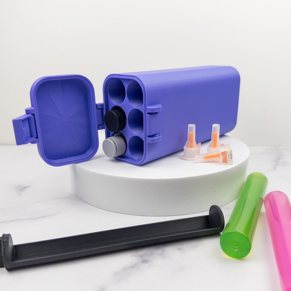 a purple container with a black lid, surrounded by various colorful plastic containers and tools on a white marble surface.