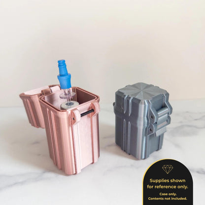 two small metal containers, one pink and one silver, placed on a marble surface.